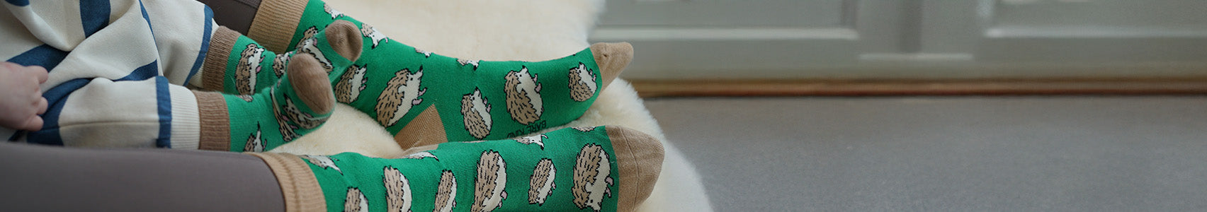Mom and baby wearing green hedgehog socks.
