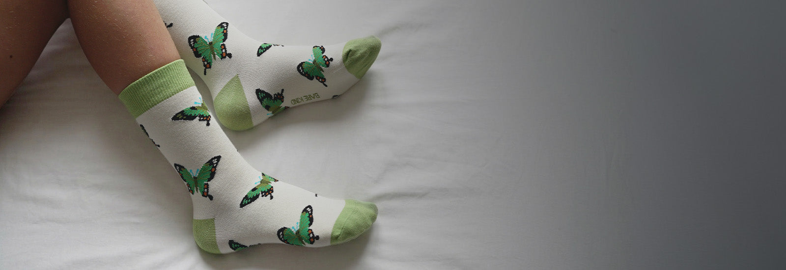 White socks with green butterflies 
on a white surface