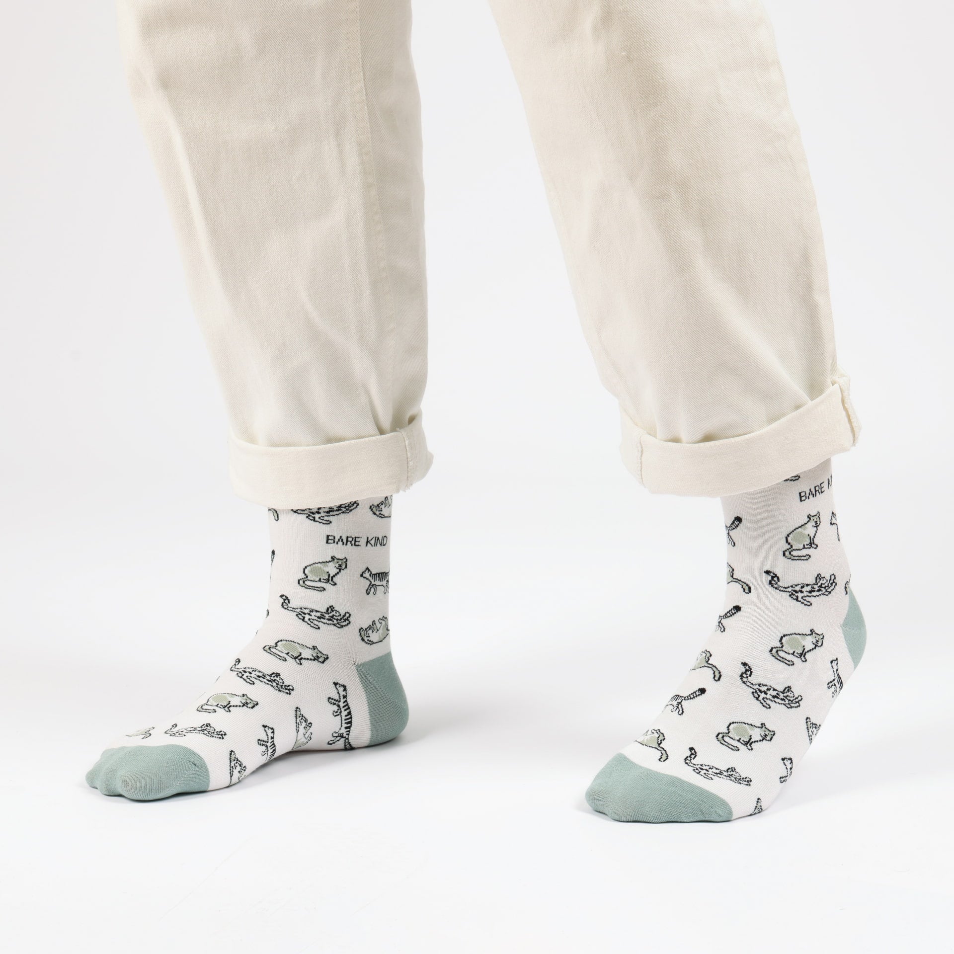 model with white trousers wearing green cat bamboo socks