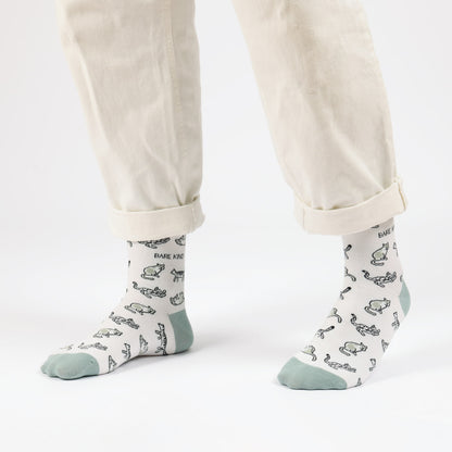 model with white trousers wearing green cat bamboo socks