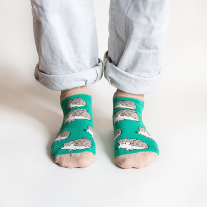 standing model wearing bamboo trainer socks in green hedgehog design