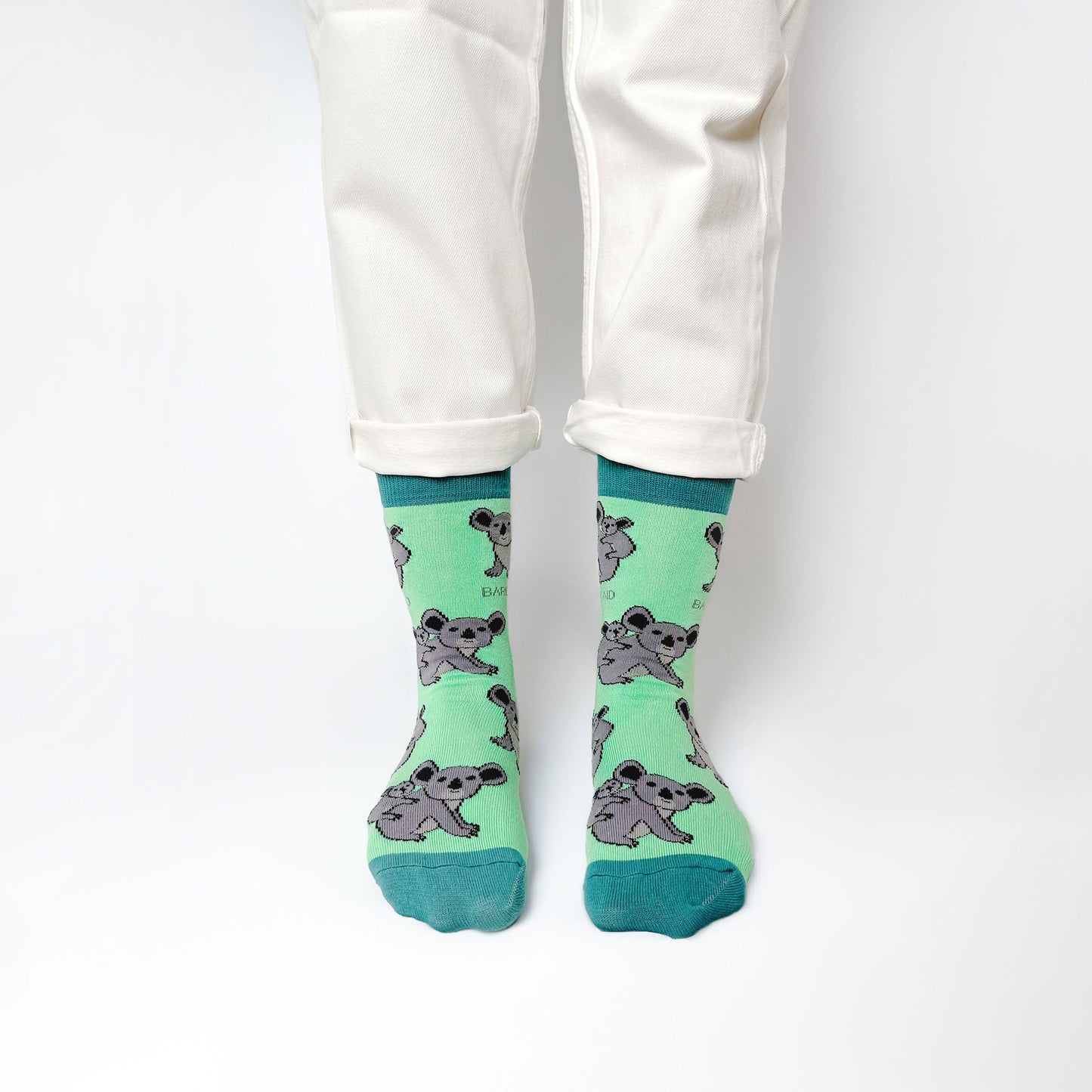 standing model wearing green koala socks made from bamboo