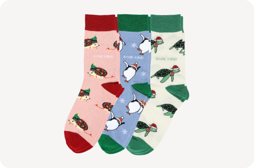 flat lay of christmas pink hedgehog, blue penguin, beige green turtle bamboo socks