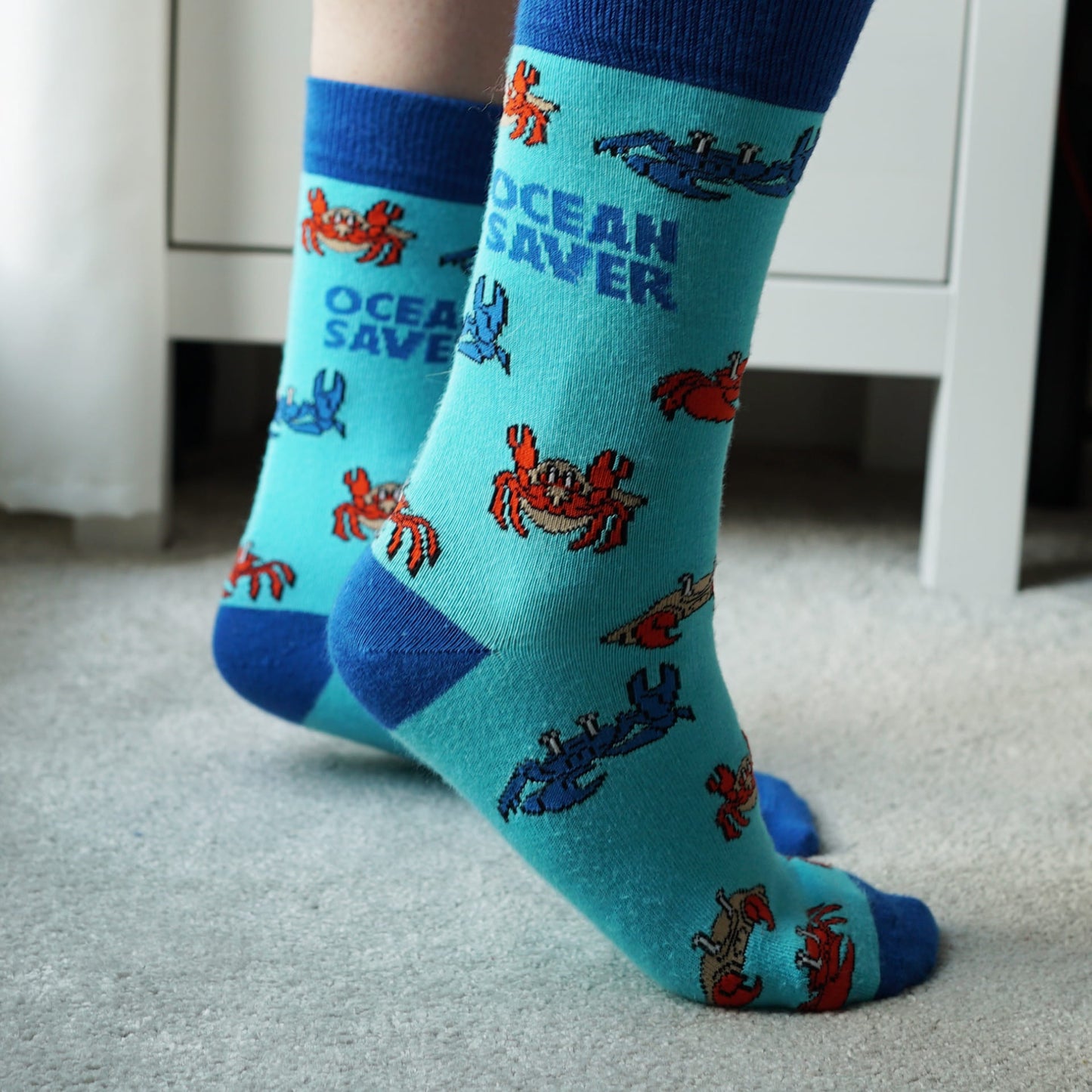 Model wearing blue Ocean Saver crab bamboo socks