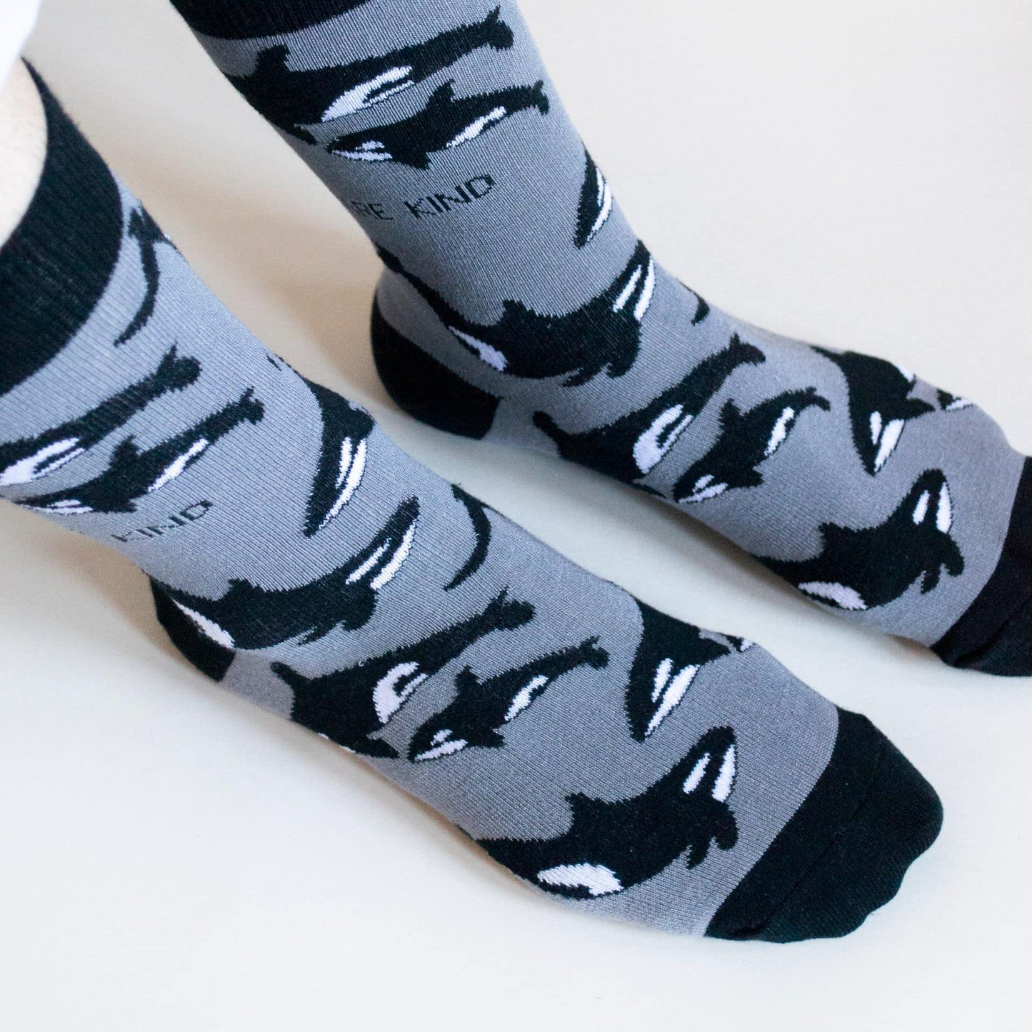 model wearing black and grey orca bamboo socks, top view