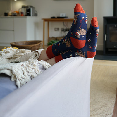 Person wearing festive socks with otter design 