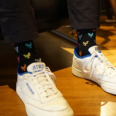 White sneakers with colorful socks on a wooden floor