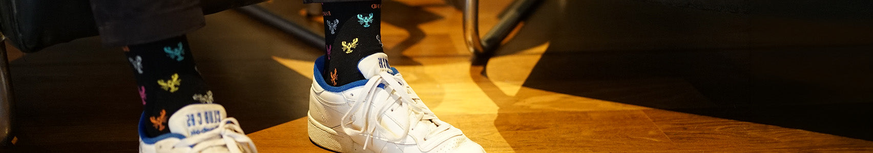 White sneakers with colorful socks on a wooden floor