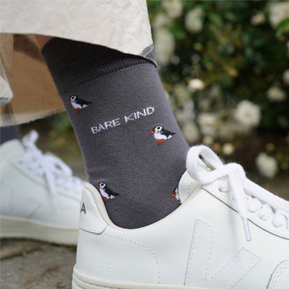 Model wearing Bare Kind bamboo socks, featuring small motifs of puffins