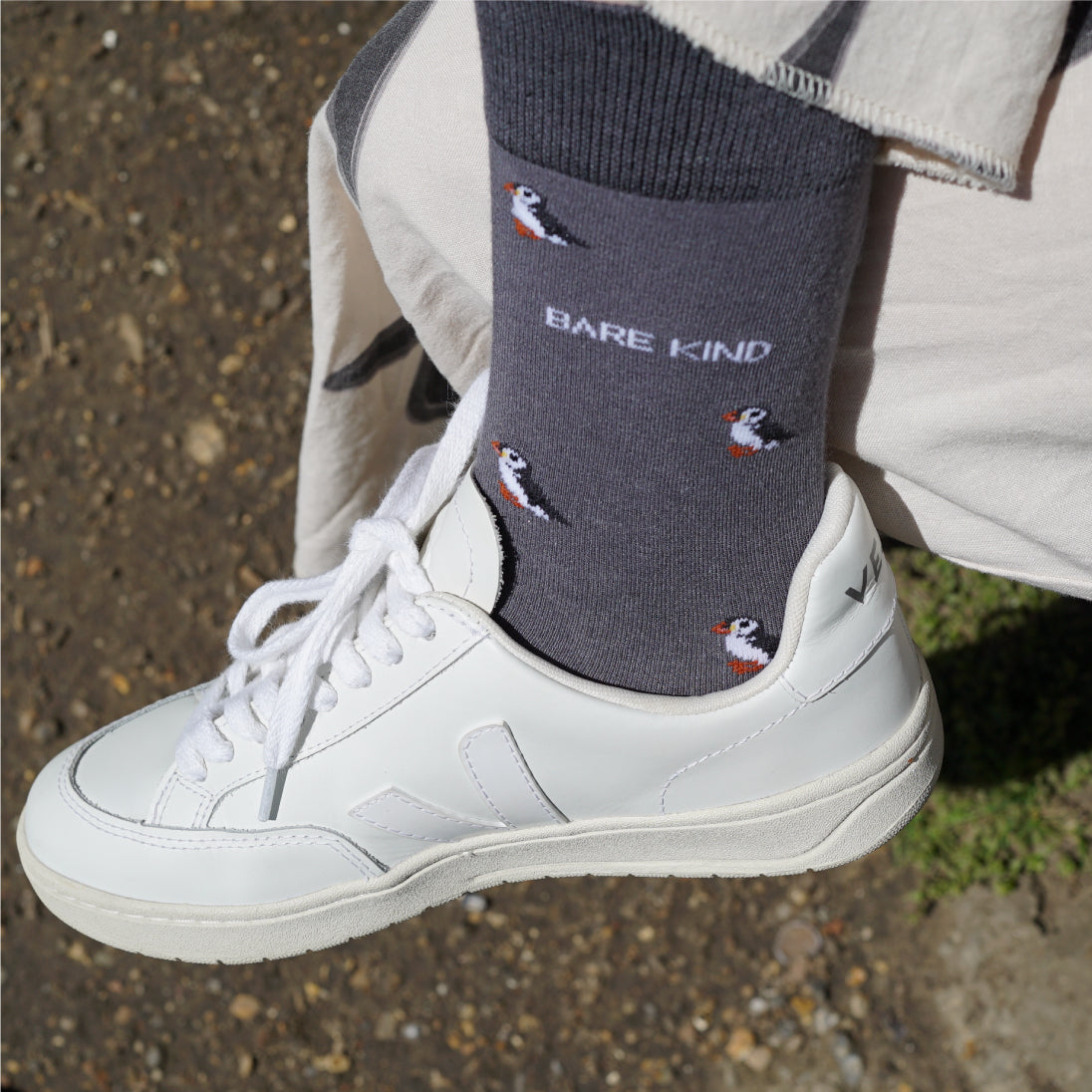 Model wearing Bare Kind bamboo socks packaging, featuring small motifs of puffins