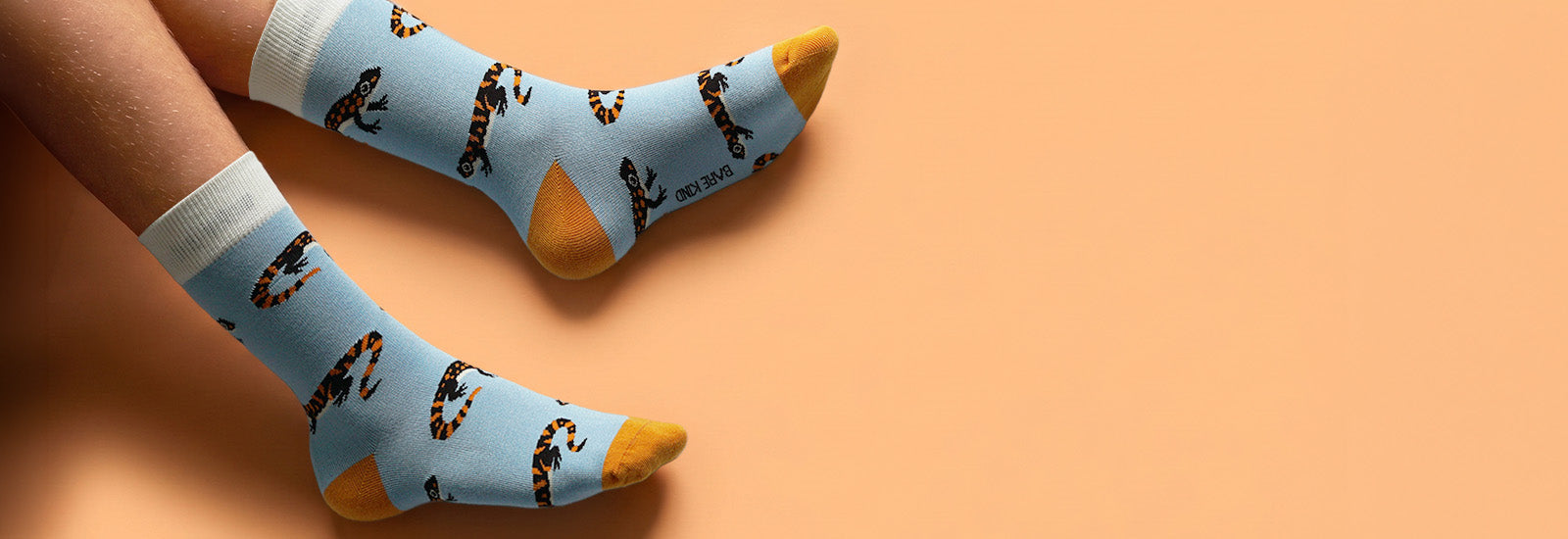 Light blue socks with salamander design on a peach background