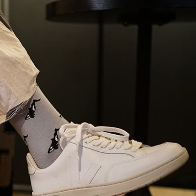 White sneakers and gray socks with orca design on a blurred background
