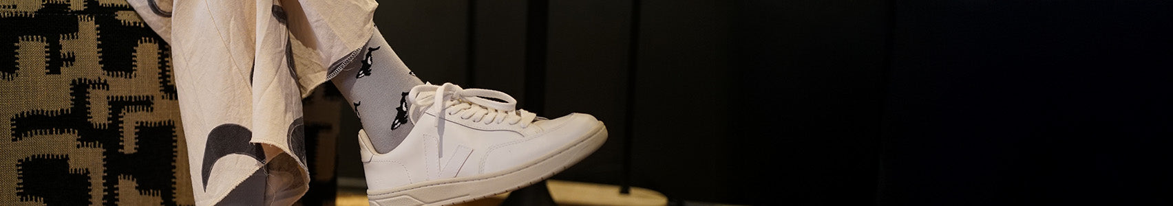 White sneakers and gray socks with orca design on a blurred background