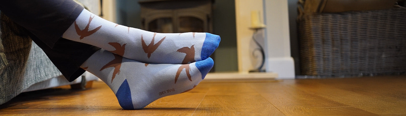 Person wearing socks with swift pattern on a wooden floor