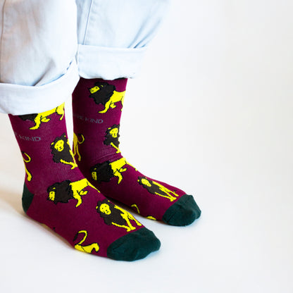 standing model wearing burgundy lion bamboo socks, side angle view