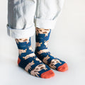side angle view of standing model wearing navy blue pig bamboo socks