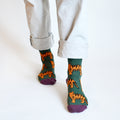 standing model wearing green bamboo tiger socks with left foot forward
