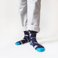 standing model wearing bamboo whale socks, front view, left foot forward and toes pointing out