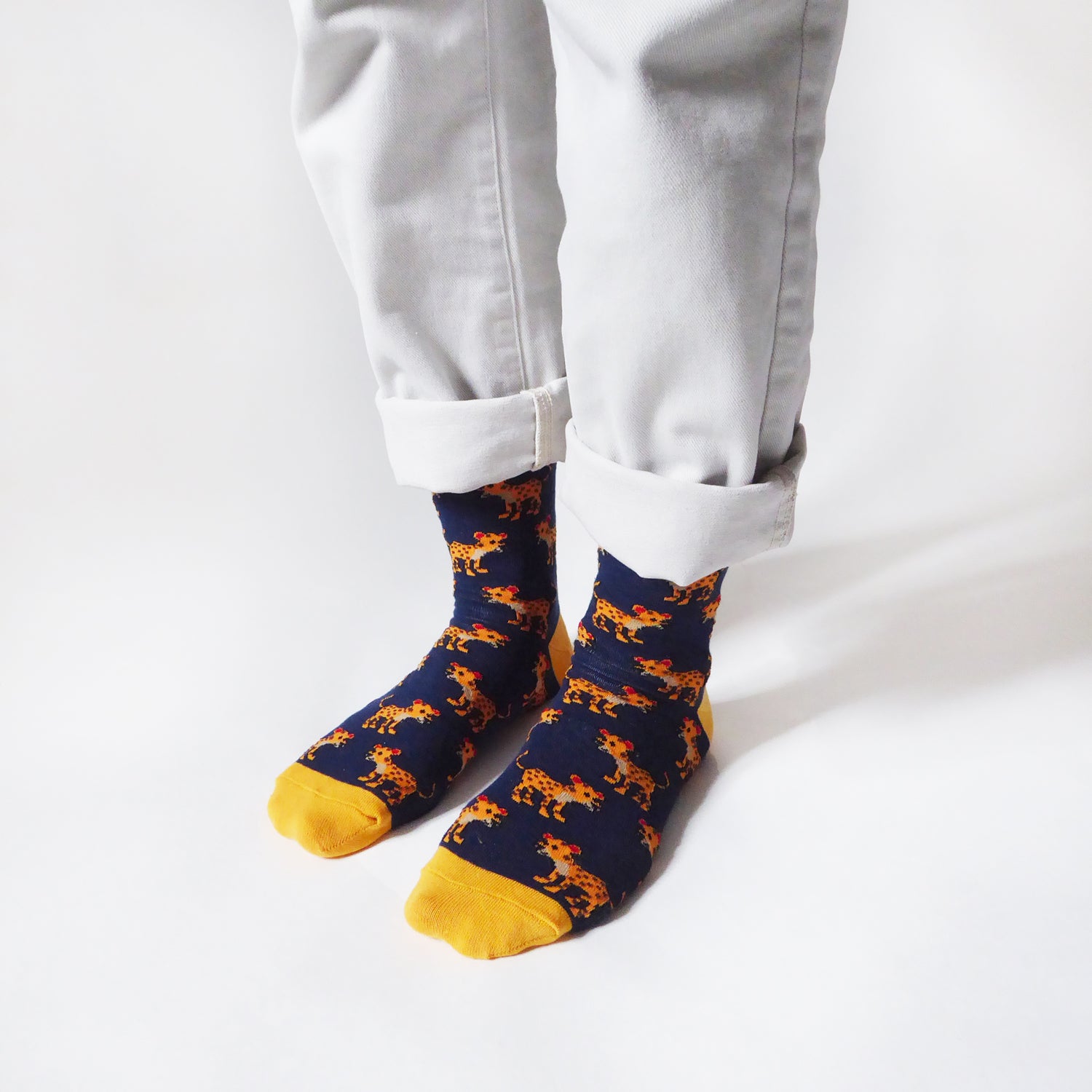 model standing, side angle view, wearing navy blue bamboo socks featuring leopard designs