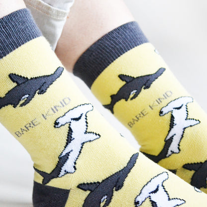 closeup of model wearing pastel yellow bamboo socks with woven shark design