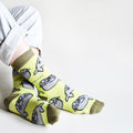 sitting model wearing lime seal socks with ankles crossed