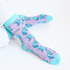 closeup of sitting model wearing lilac and blue bamboo frog socks as the ankles are crossed