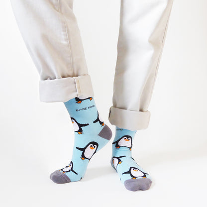 front view of standing model wearing sky blue bamboo penguin socks with the right heel lifted